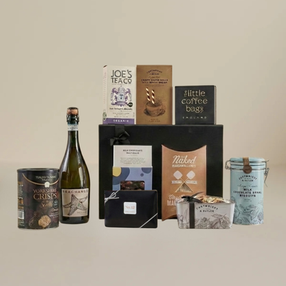 Luxury food and wine flatlay with milk chocolate malt balls, biodegradable coffee bags, wafer rolls, and gourmet marshmallows.