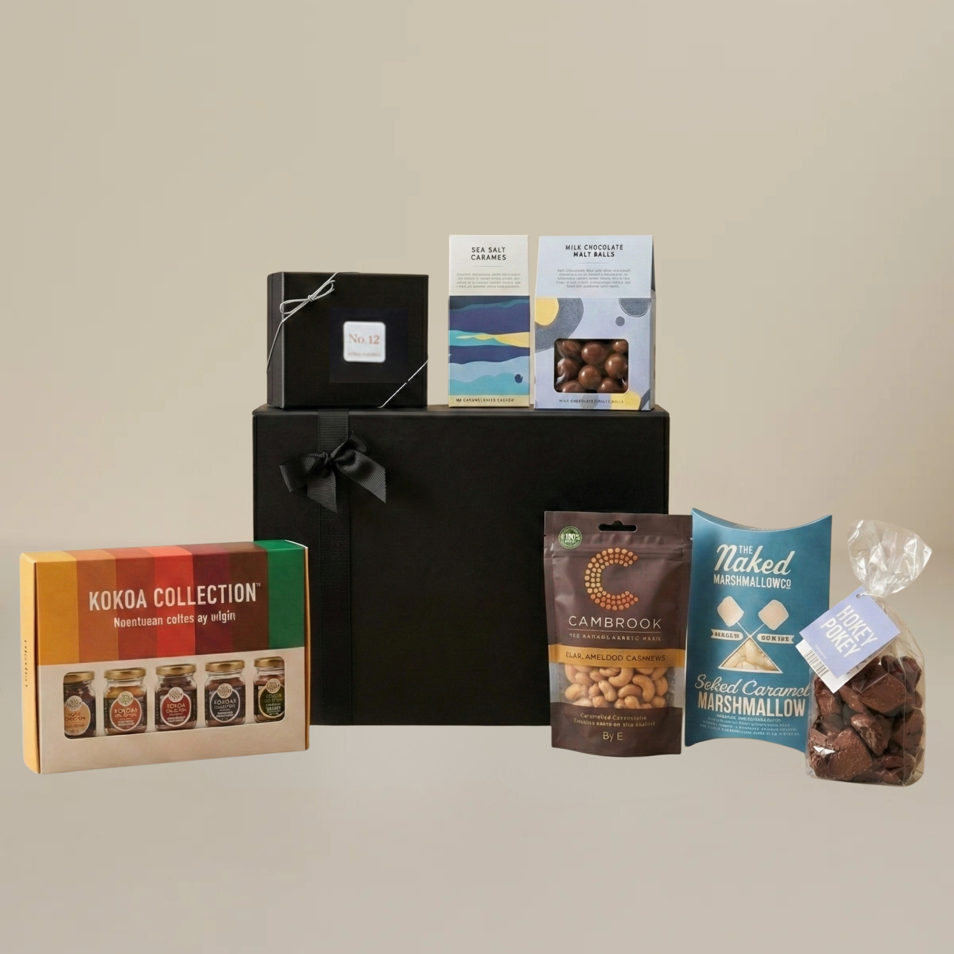 Luxury chocolate gift set flatlay with milk chocolate malt balls, artisan chocolate bar, caramelised peanuts, and hot cocoa collection.