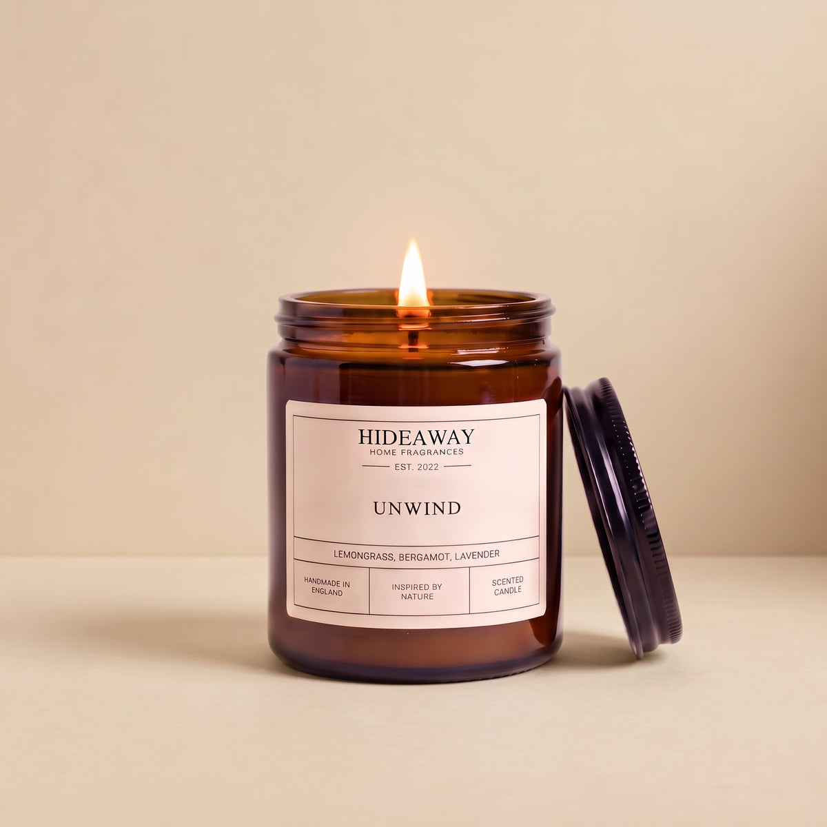 Hand-poured unwind amber glass candle featuring notes of relaxing lavender, warm chamomile, and soft sandalwood, Hideaway Home Fragrances