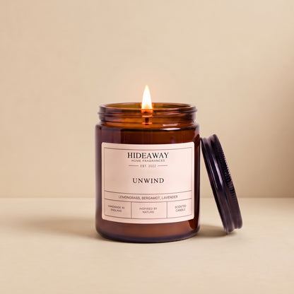 Hand-poured unwind amber glass candle featuring notes of relaxing lavender, warm chamomile, and soft sandalwood, Hideaway Home Fragrances