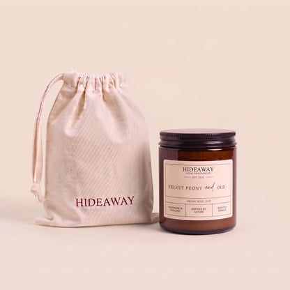 Luxurious velvet peony and oud aromatic candle in an amber glass jar creating a rich romantic atmosphere from Hideaway Home Fragrances