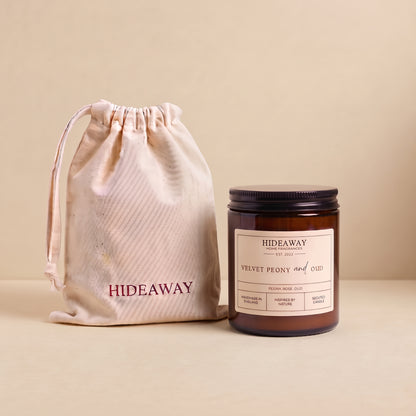Luxurious velvet peony and oud aromatic candle in an amber glass jar creating a rich romantic atmosphere from Hideaway Home Fragrances