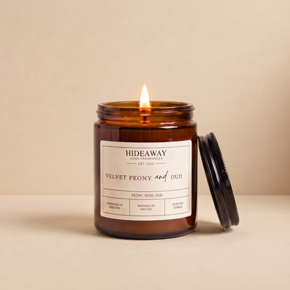 Hand-poured velvet peony and oud amber glass candle featuring notes of lush peony, smoky oud wood, and damask rose, Hideaway Home Fragrances