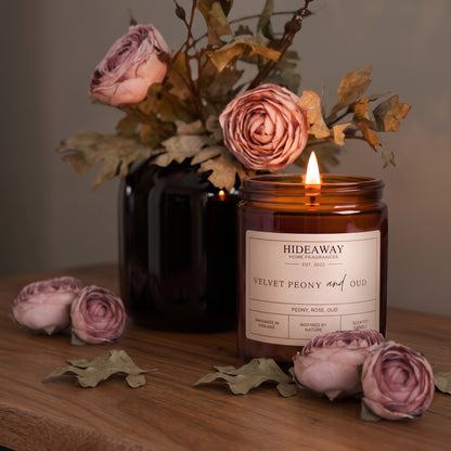 Opulent velvet peony and oud amber glass jar candle styled on a dark marble coffee table, Hideaway Home Fragrances