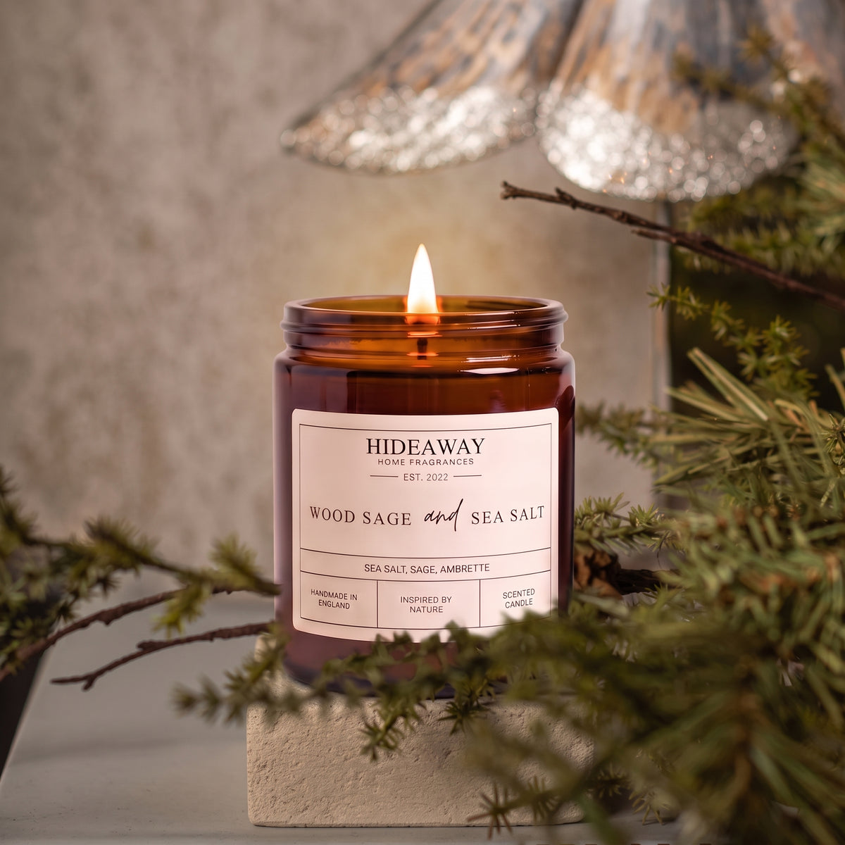 Aromatic wood sage and sea salt amber glass jar candle styled on a coastal wooden windowsill, Hideaway Home Fragrances